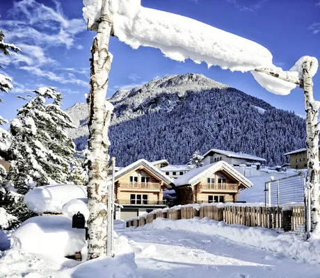 Blick auf die schneebedeckten Summit Lodges mit blauem Himmel und Bergen im Hintergrund
