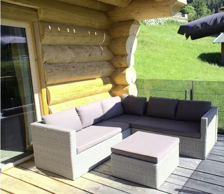 Gemütliche Sitzgarnitur mit Polstern und dunkelblauer Sonnenschirm auf der Terrasse der Summit Lodges