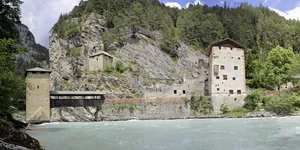 Blick auf die Erlebnisburg Alt-Finstermünz in der Nähe der Summit Lodges an einem Felsen direkt an einem türkisgrünen Fluss und umgeben von Wald