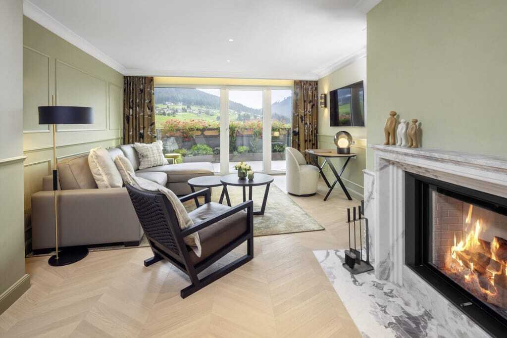 Suite im Hotel Bareiss mit brennendem Kamin und schwarzem Holzsessel