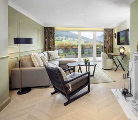 Suite im Hotel Bareiss mit brennendem Kamin und schwarzem Holzsessel