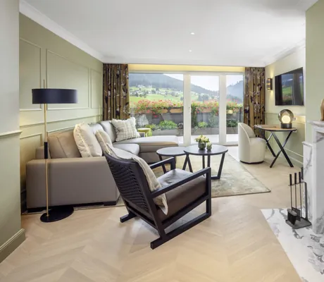 Suite im Hotel Bareiss mit brennendem Kamin und schwarzem Holzsessel