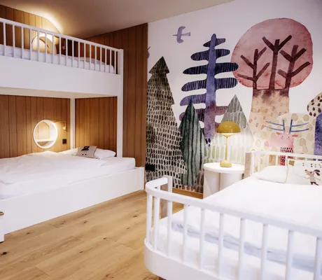 Kinderzimmer des Familotel Landhaus Averbeck mit weißem Bett, weißem Stockbett, Holzboden, Holzwand und bunter Wandmalerei mit verschiedenen Bäumen