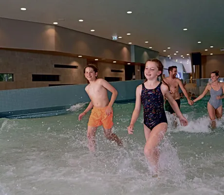 Eltern mit zwei Teenager-Kindern kommen aus dem Pool des Weissenhäuser Strand