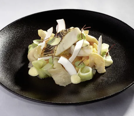 Fischgericht mit Gemüse auf tiefem schwarzen Teller im Hotel 47°
