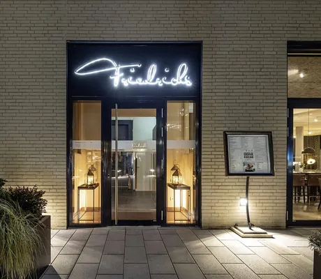 beleuchteter Eingang des Restaurant Friedrich im Hotel 47° mit Neonschrift