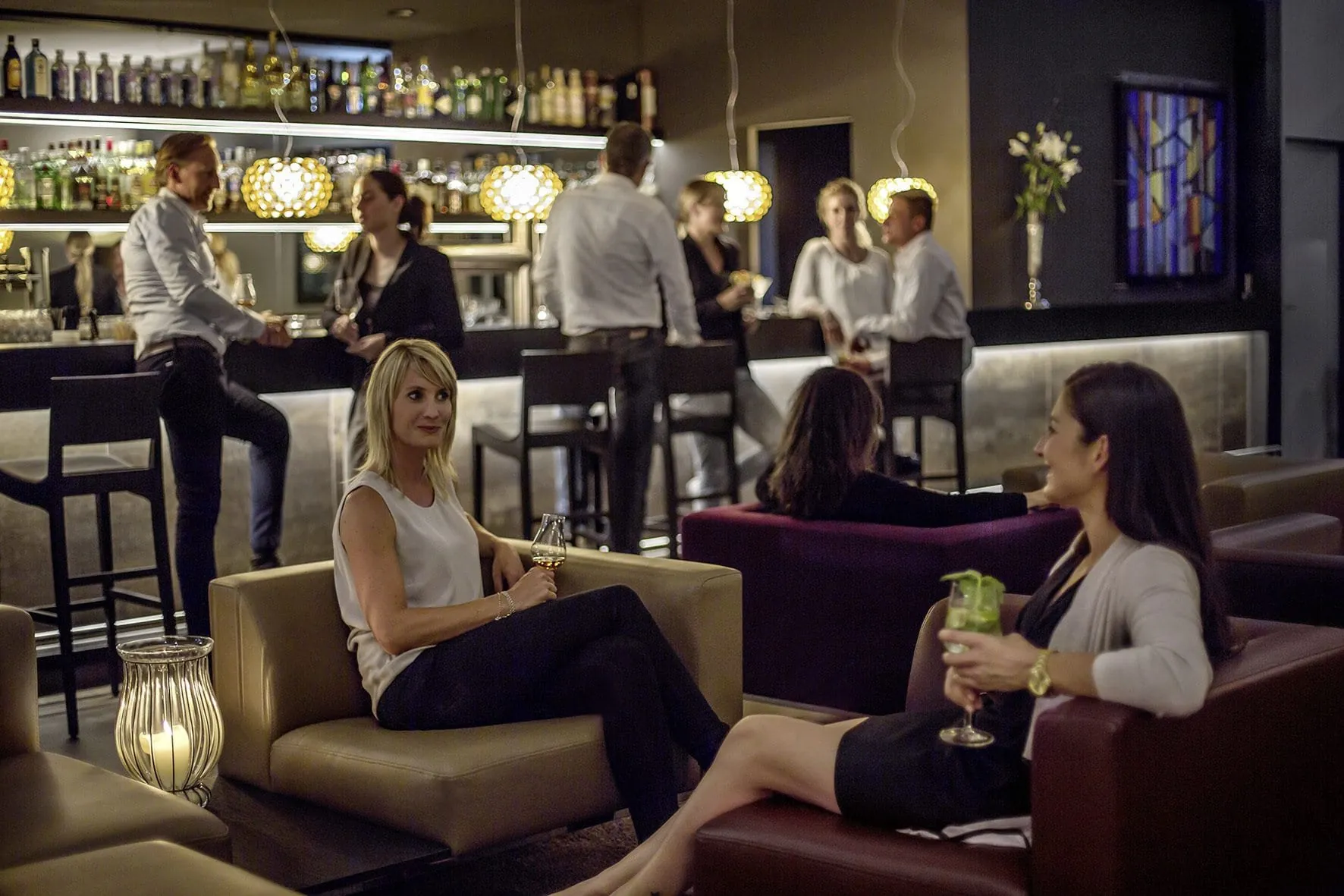 Menschen an der Bar des Hotel 47&deg; und in den Loungesesseln davor