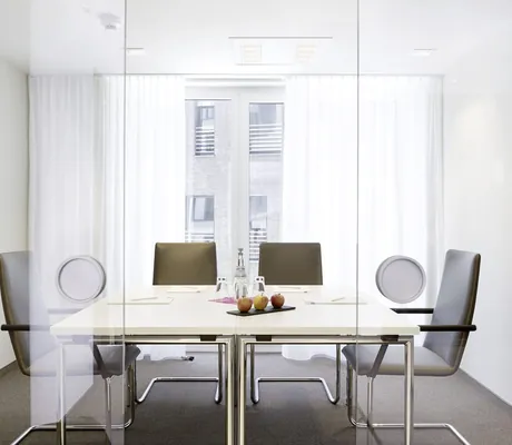 Besprechungsraum für vier Personen im Hotel 47° mit mokkafarbenen Freischwingern und weißem Tisch