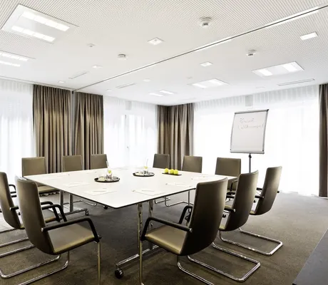 Tagungsraum im Hotel 47° für zwölf Personen mit mokkafarbenen Freischwingern und mokkafarbenen Gardinen