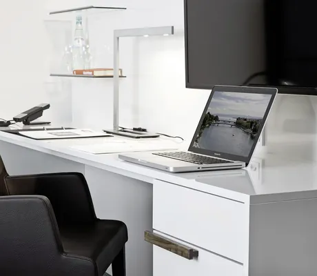 weißer Schreibtisch mit Notebook im Zimmer des Hotel 47° mit schwarzem Sessel