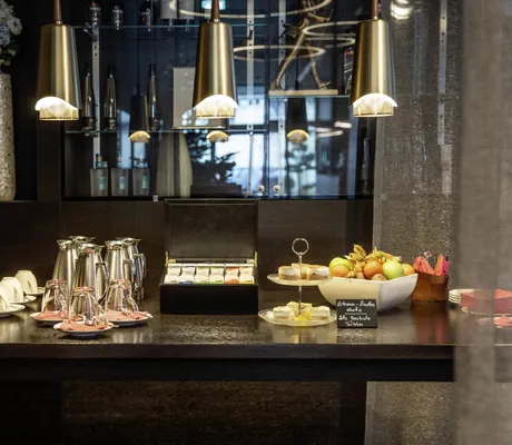 Pausenbuffet im Tagungsbereich des Hotel 47° mit goldenen Hängeleuchten, Obstkorb und Törtchen