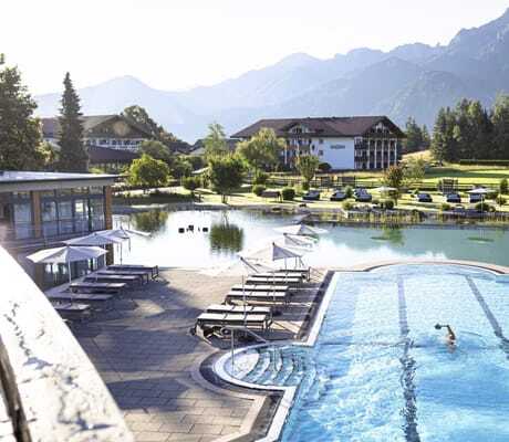 Mann schwimmt im Sportpool des Das König Ludwig Inspiration SPA eingebettet in den Schwanensee