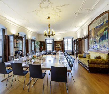 Tagungsraum in der Bibliothel des Schloss Lautrach mit altem Sofa und Kronleuchter