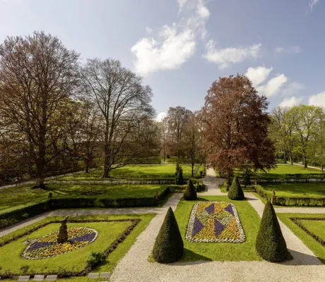 Park des Schloss Lautrach mit sehr gepflegt angelegten Beeten und uraltem Baumbestand