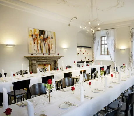 lange eingedeckte Tafeln in Schloss Lautrach mit roten Rosen