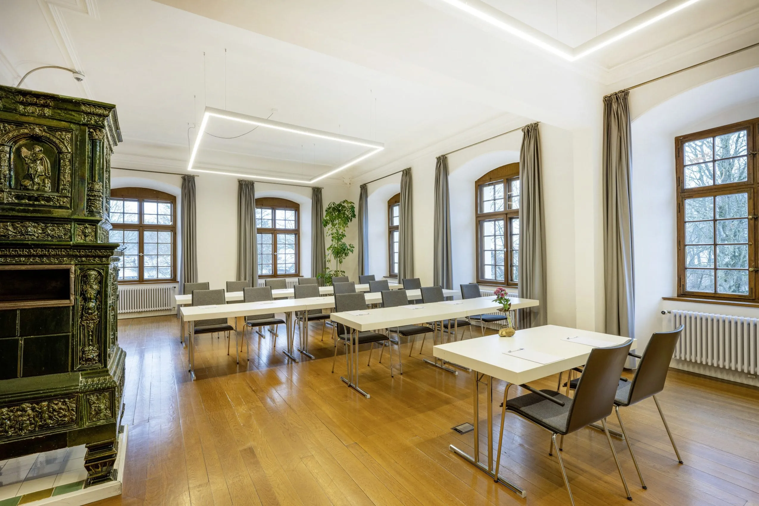 Tagungsraum im Schloss Lautrach mit gro&szlig;em altem gr&uuml;nen Kamin