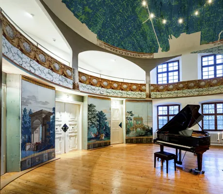 runder antiker Theatersaal im Schloss Lautrach mit Fresken und Piano in der Mitte