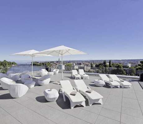 Dachterrasse des Hotel 47° mit weißen Loungemöbeln und Sonnenschirmen mit Blick auf den Seerhein