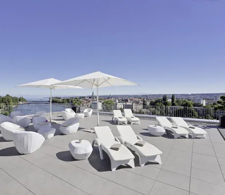 Dachterrasse des Hotel 47° mit weißen Loungemöbeln und Sonnenschirmen mit Blick auf den Seerhein