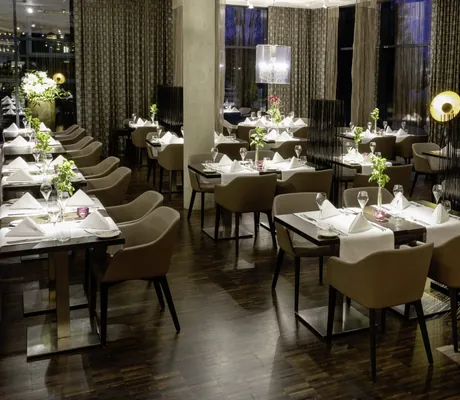 stylisches Restaurant im Hotel 47° mit eingedckten Tischen und Fadenvorhängen als Abtrennung
