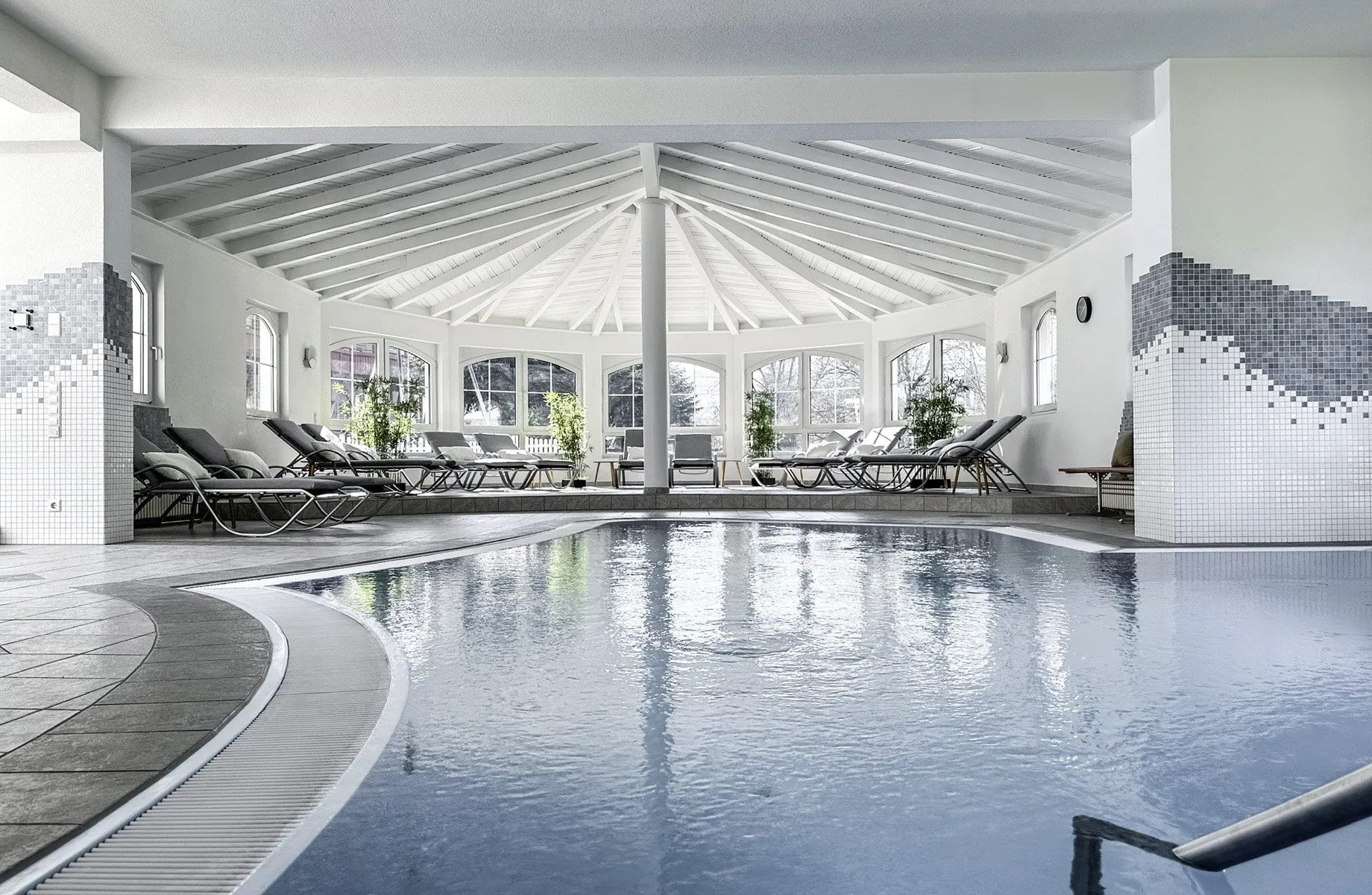 Indoorpool des Wellnesshotels Badischer Hof mit grauen Liegen