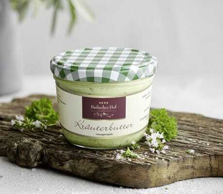 hausgemachte Kräuterbutter auf einem Holzbrett des Wellnesshotel Badischer Hof in einem Glas mit grün, kariertem Deckel