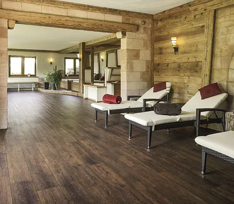 Ruheraum im Wellnesshotel Badischer Hof mit Liegen, Holzverkleidung, großen Fenstern und dunklem Holzboden