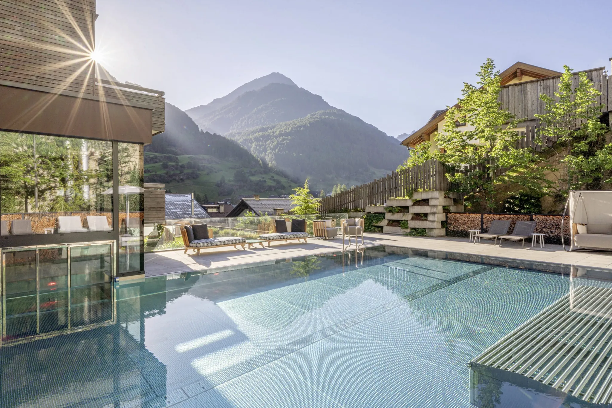 Outdoorpool im Bergland Sölden mit Whirlliegen und Blick auf die Berge