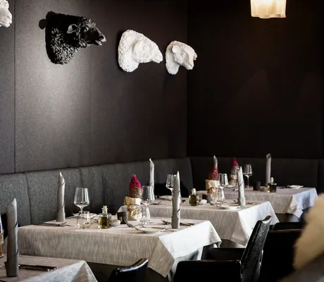 Restaurant im Bergland Sölden mit schwarz gestrichenen Wänden und Schafsköpfen aus Porzellan an der Wand