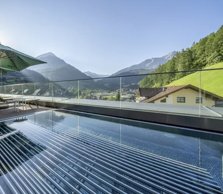 Outdoor-Whirlpool im Bergland Sölden mit grünen Sonnenschirmen auf der Terrasse