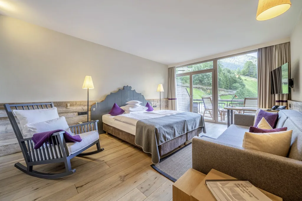 Zimmer im Bergland Sölden mit großem blauem Schaukelsessel und Balkon