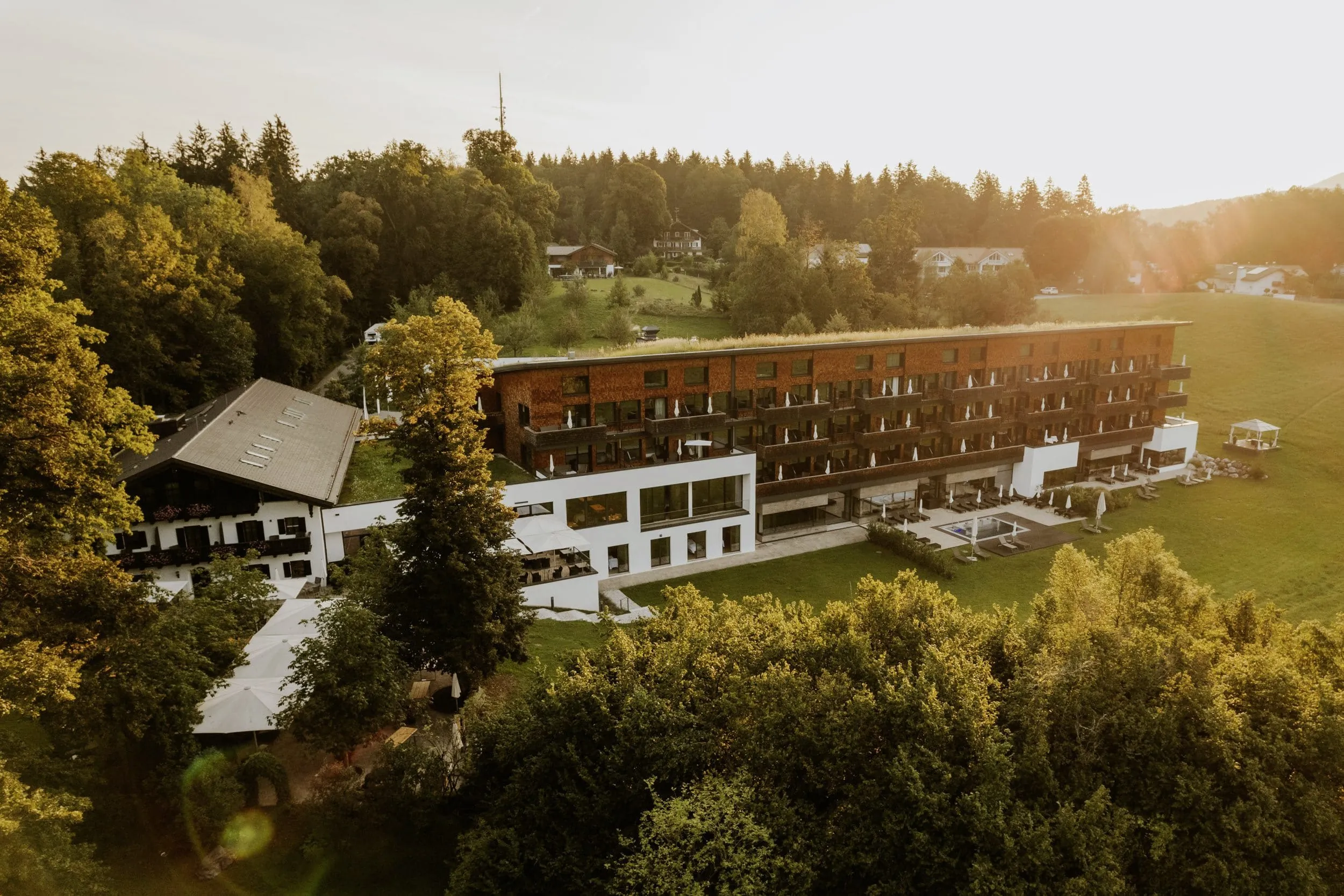 Außenansicht des Klosterhof - Alpine Hideaway & Spa inmitten grüner Wiesen und Wälder