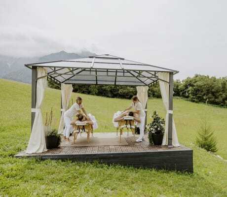 Paarmassage im Outdoor-Pavillon des Klosterhof - Alpine Hideaway & Spa auf der Wiese