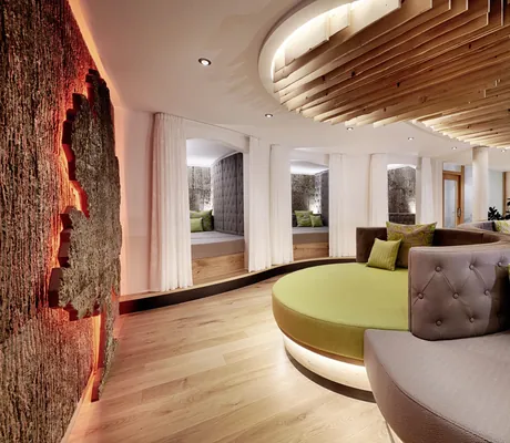 grün-graue runde Liegen, Hängesessel im Hintergrund und drei große Ganzkörperspiegel im Spa-Bereich des Wellnesshotels Kronelamm