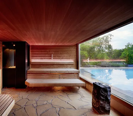 Sauna mit großem Fenster und Ausblick auf den Pool des Wellnesshotels Kronelamm