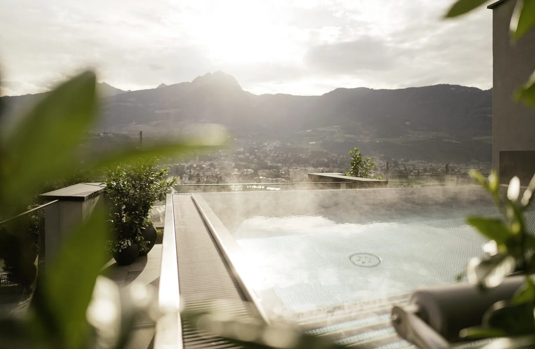 Outdoorpool im La Maiena Meran Resort mit aufsteigendem Dampf