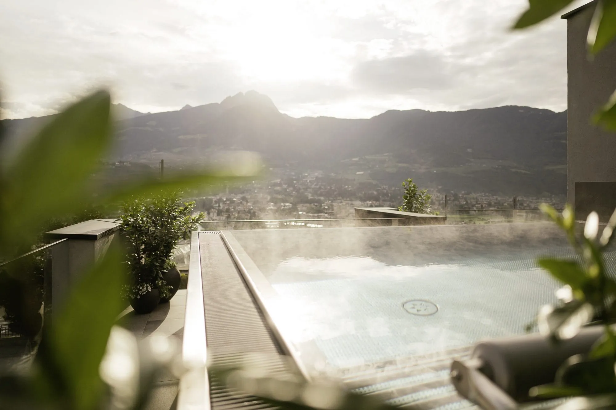 Outdoorpool im La Maiena Meran Resort mit aufsteigendem Dampf