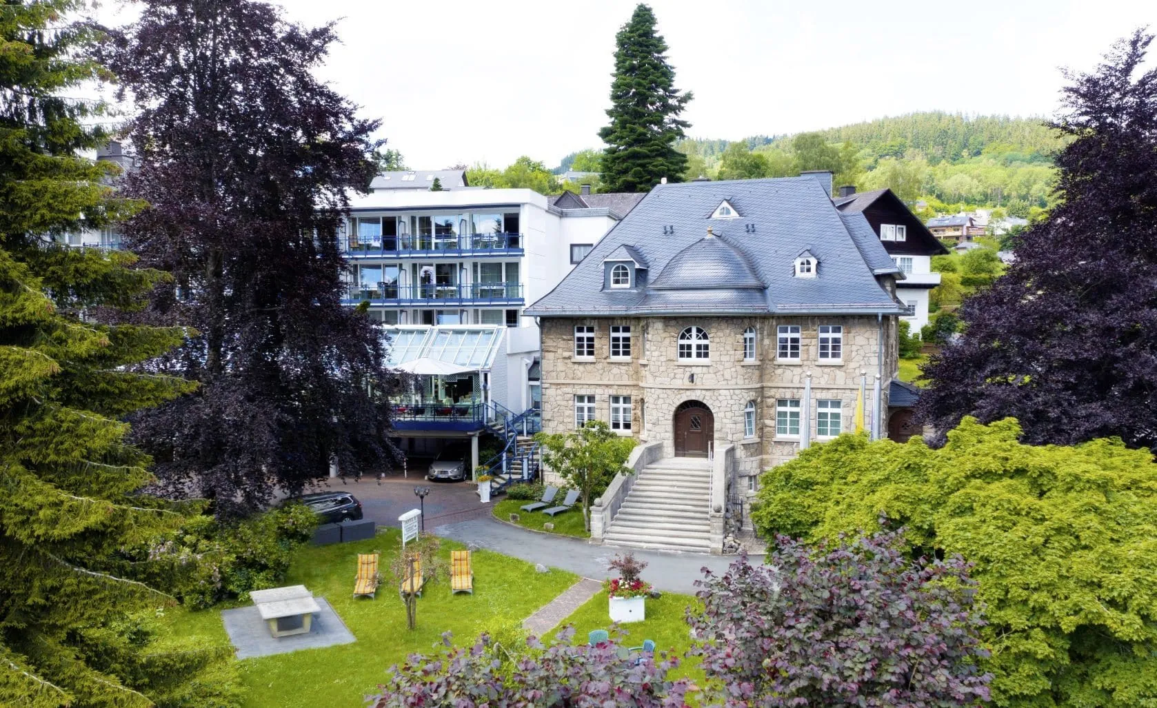 historisches Haupthaus und weißer Anbau des Rüters Parkhotel mit Blick in den Park