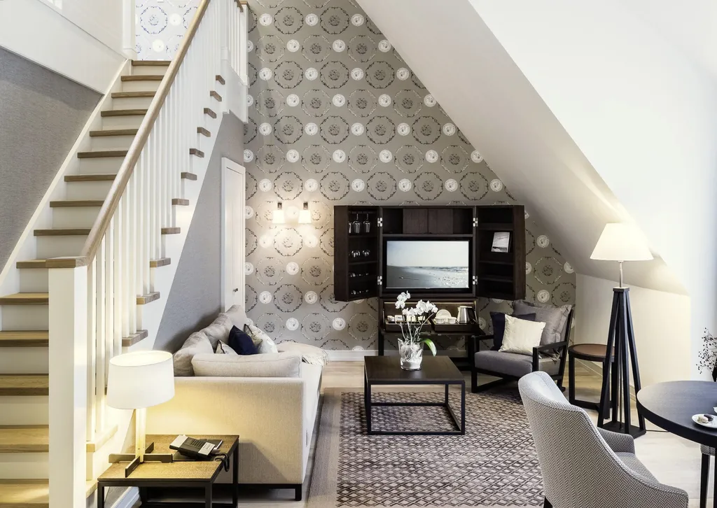 Maisonnette Suite im Severin*s Resort & Spa mit Fernseher im aufklappbaren Schrank und grauer Mustertapete