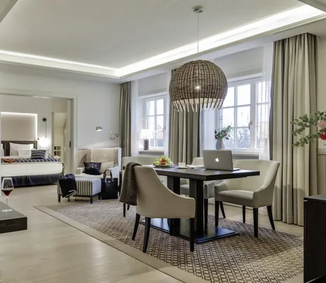 Suite im Severin*s Resort & Spa mit großer Korb-Hängeleuchte über dem Tisch und brennendem Kamin