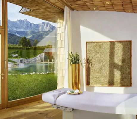 Spa-Suite im Bio- & Wellnessresort Stanglwirt mit weißer Liege und Blick auf Badeteich und weiße Lipizzaner