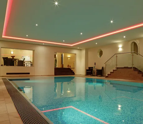 Indoorpool im Hotel Waldblick Kniebis mit roten Lichtleisten an der Decke