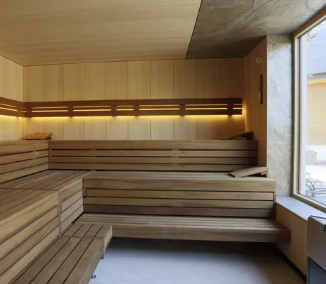 gelb beleuchtete Sauna im Hotel Waldblick Kniebis mit großem Fenster