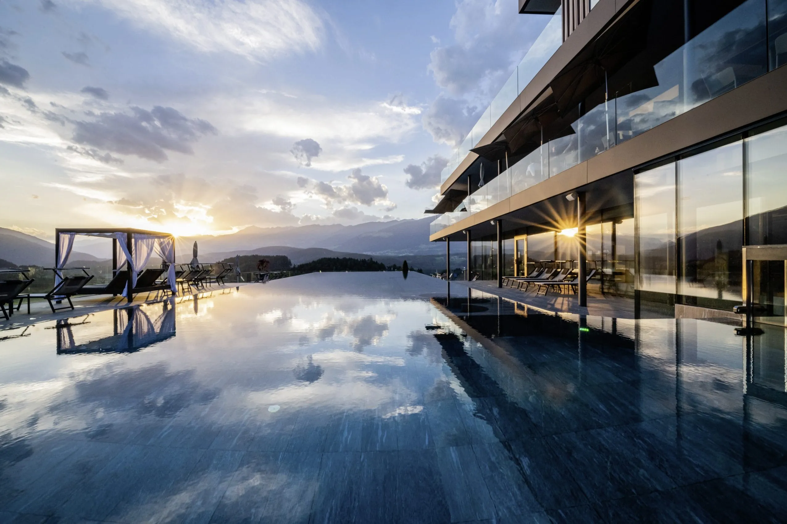 Panorama-Outdoorpool im Hotel Winkler im Sonnenuntergang mit Daybed