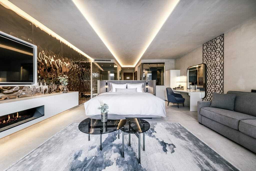 Suite in der Quellenhof See Lodge mit metallischer Wand und blaugemustertem Teppich