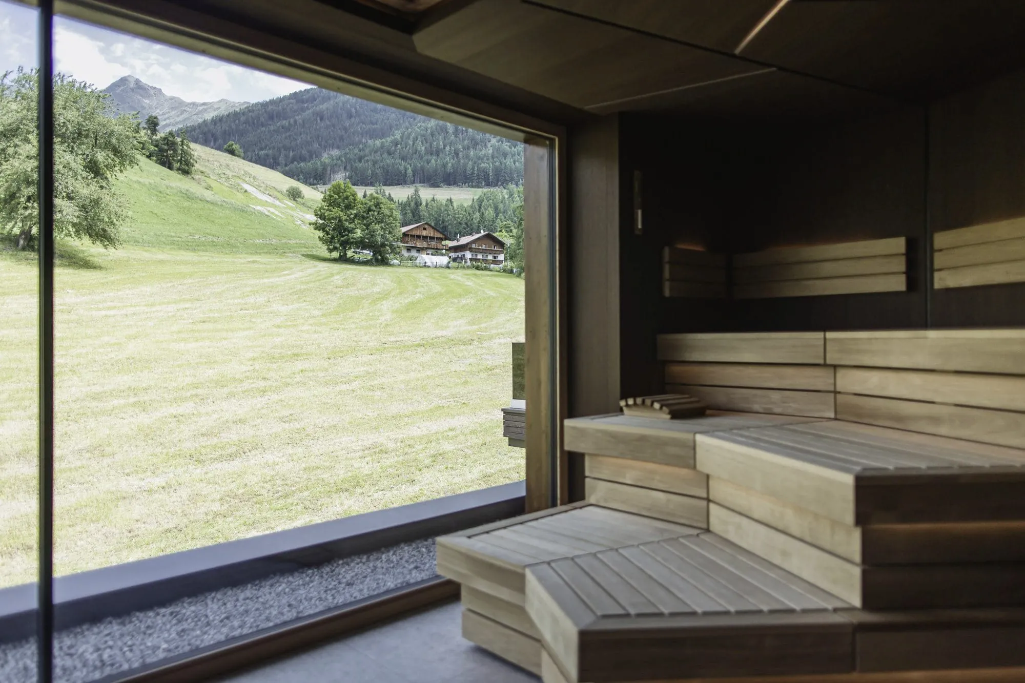 Panoramablick auf den grünen Hang von der Sauna des Terentnerhof