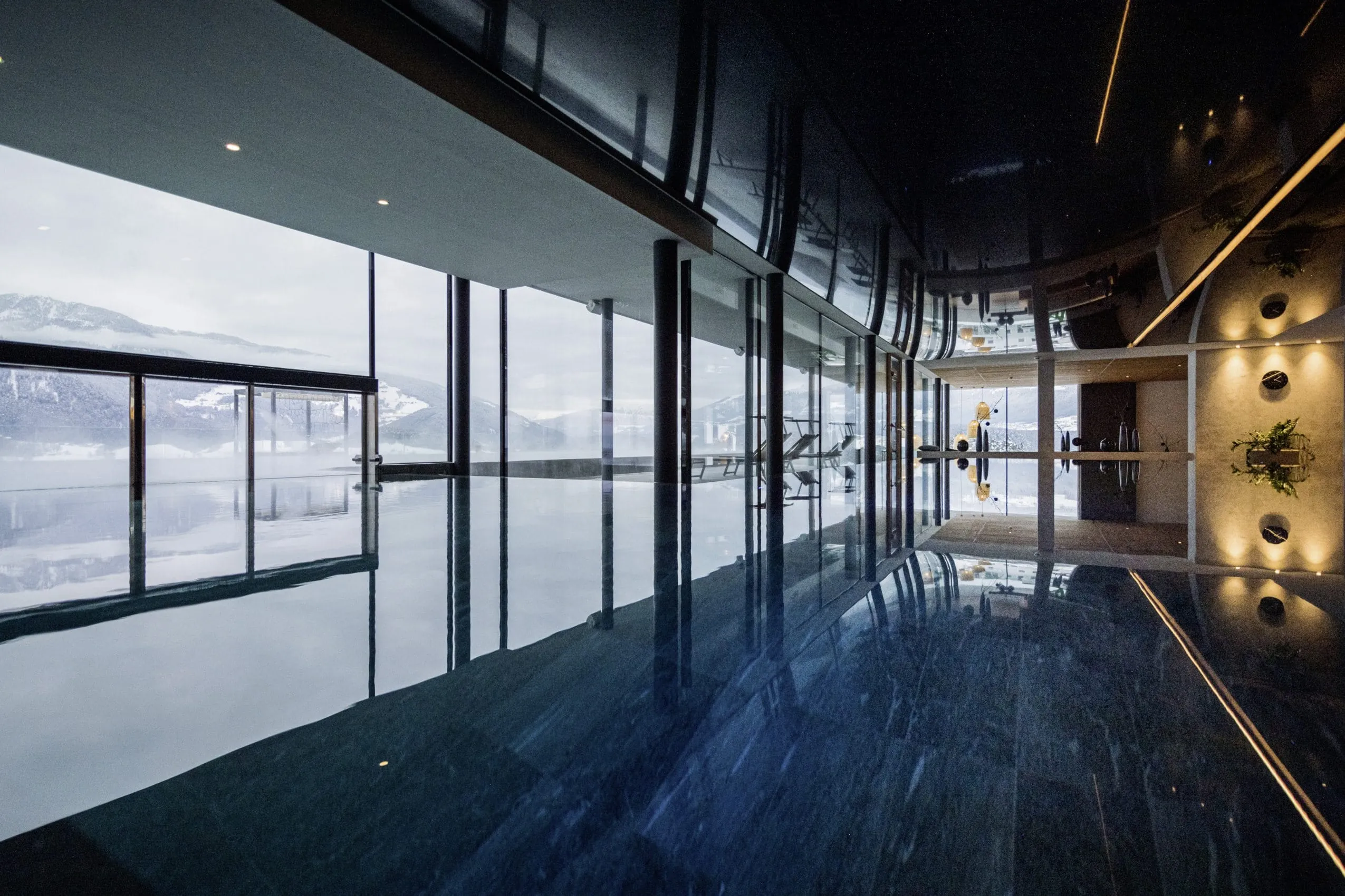 Indoorpool mit angrenzendem Outdoorpool und Bergpanorama im Wellnesshotel Winkler