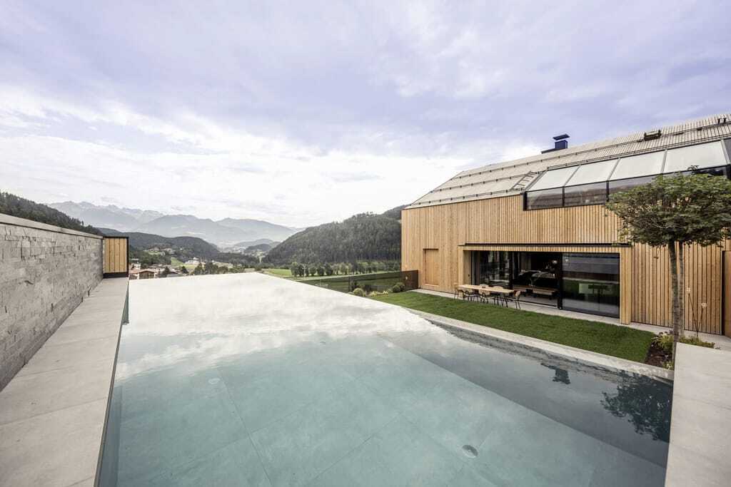 Sky Relax Outdoorpool des PURMONTES Private Luxury Chalet mit Blick auf die Berge im Sommer