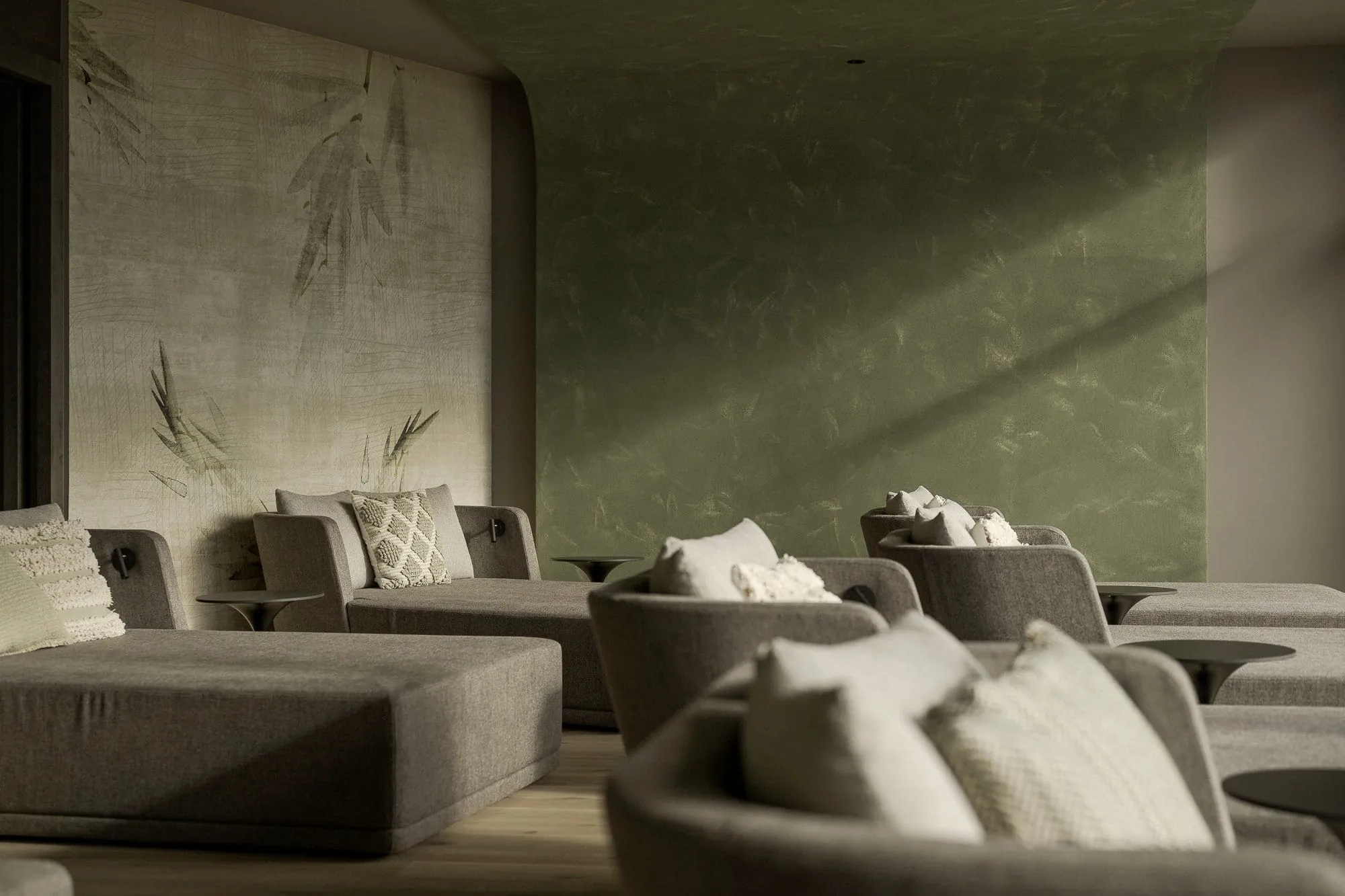 Ruheraum im La Maiena mit grüner Wand und grauen Stoffliegen