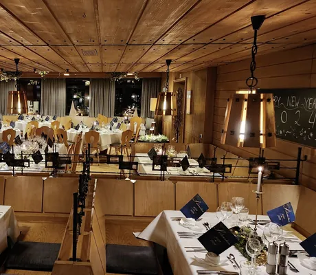 Blick in das Restaurant des Hotel Speidel’s BrauManufaktur mit Holzbänken und -stühlen und gedeckten Tischen